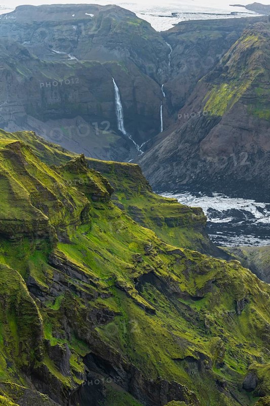 Moss-covered mountains at sunset, waterfalls on a cliff at Myrdalsjökull glacier, Pakgil, Iceland