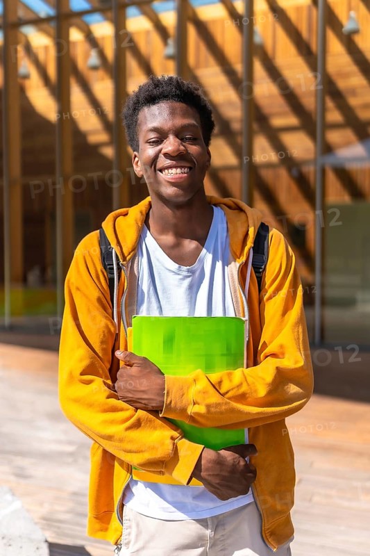 Vertical portrait of a confident and smiling african american student outside the university