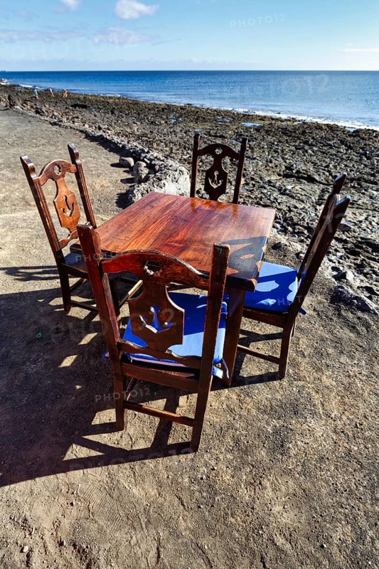 Wooden table and four chairs, fish restaurant on the beach, Playa Quemada, Yaiza, Lanzarote, Spain