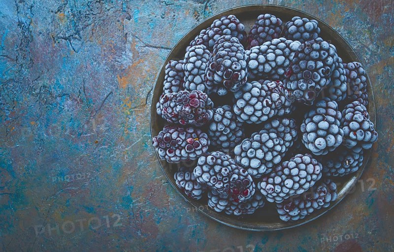 Freshly frozen, blackberries on a plate, top view, no people