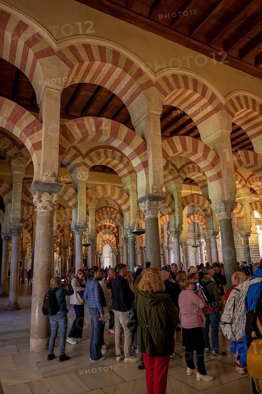People gather in the cathedral mosque of Cordoba (Mezquita-Catedral), with its magnificent arches and impressive architecture, Cordoba, Andalusia, Spain