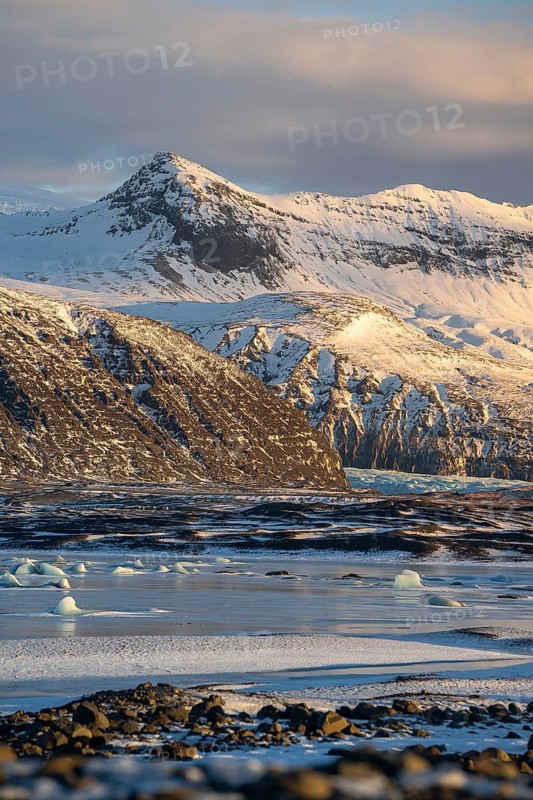 Captivating view of Iceland's snowy mountains, icy beaches, and ethereal landscapes at sunset in Skaftafell. A serene yet dramatic beauty of Iceland's wilderness