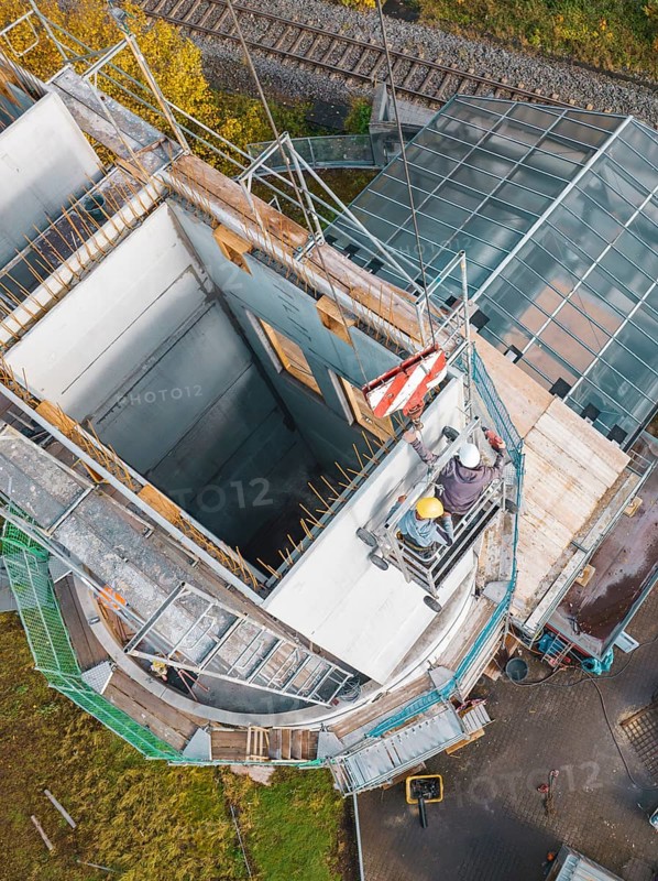 View from above of work on a concrete tower next to a railway line and glass roofing, Calw railway station conversion for Hermann Hessebahn, Calw, Black Forest, Germany