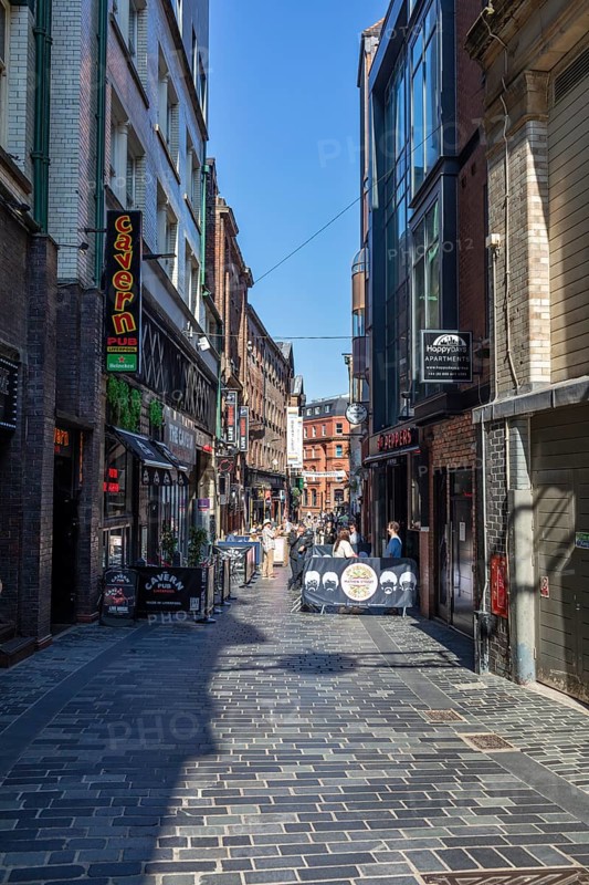 Narrow street in a town with various pubs and shops, Liverpool