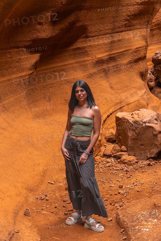 Young woman exploring the unique geological formations of barranco de las vacas, a popular tourist destination in gran canaria, spain
