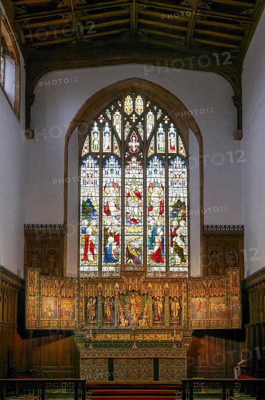 Stained glass east window, elaborately carved gilt altar reredos screen 1938, church of Saint John the Baptist, Peterborough, Cambridgeshire, England, UK