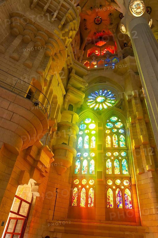 Sunlight streaming through vibrant stained glass windows, creating a mesmerizing display of color and light within the sagrada familia basilica