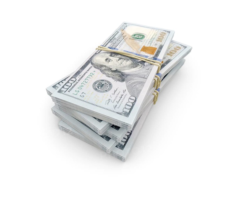 Stacks of thousands of one hundred dollar bills bound by a rubber band isolated on a white background