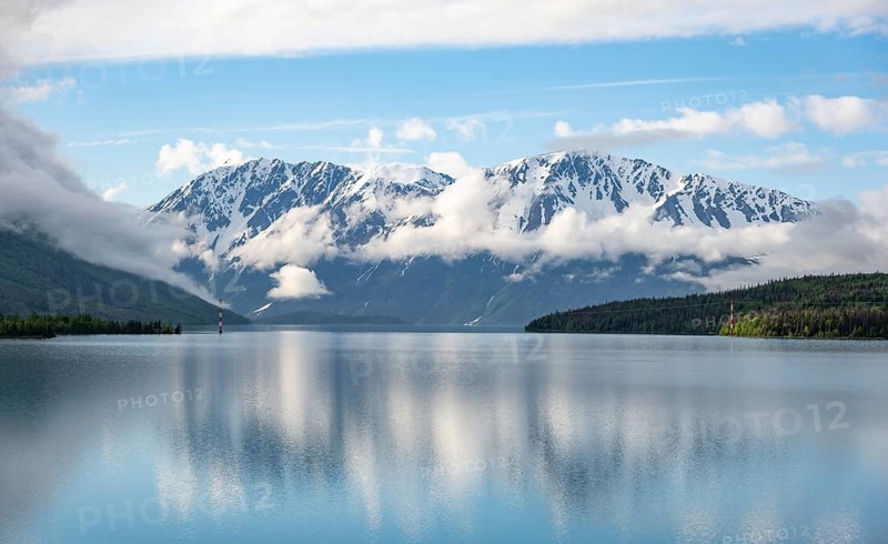 Snowy mountains in spring are reflected in turquoise blue Kenai Lake, Cooper Landing, Kenai Peninsula, Alaska, USA