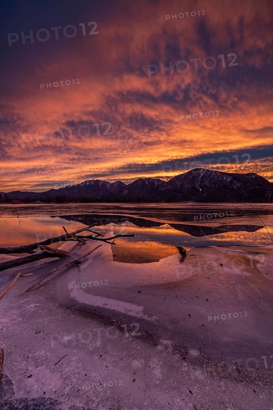Dawn, mountains reflected in lake, clouds, ice, frozen, winter, Lake Kochel, view of Rabenkopf, Sonnenspitz, Jochberg, Alpine foothills, Bavaria, Germany