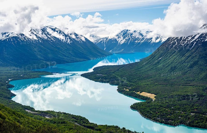 View of snowy mountains in spring and turquoise Kenai Lake with reflection, Slaughter Ridge Trail, Cooper Landing, Kenai Peninsula, Alaska, USA