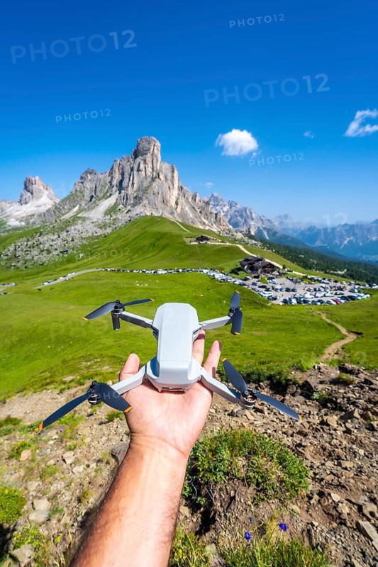 Hand holding a drone ready to fly over the beautiful landscape of passo giau in the italian dolomites