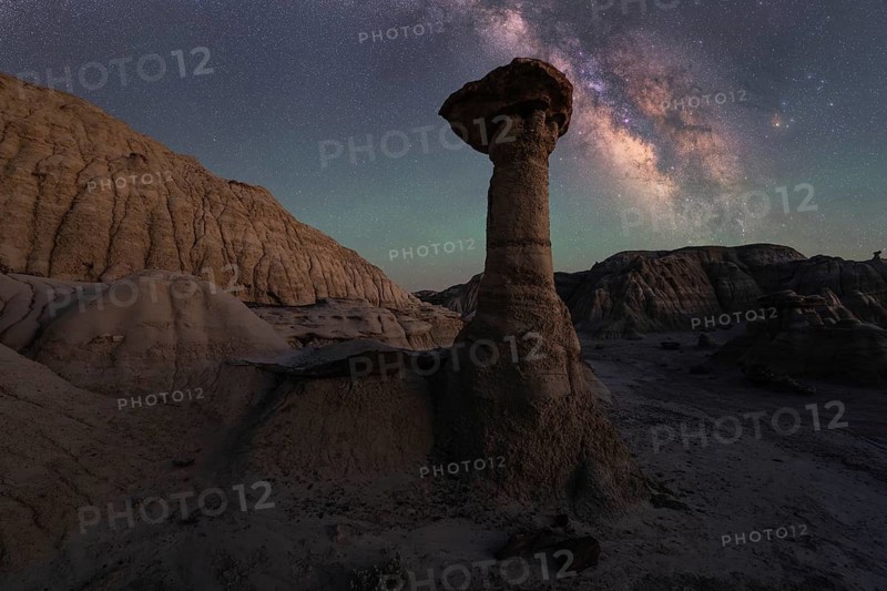 A mesmerizing night view in Goblin Valley State Park, Utah. The Milky Way glows over distinctive sandstone formations, creating a serene desert landscape under a starlit sky