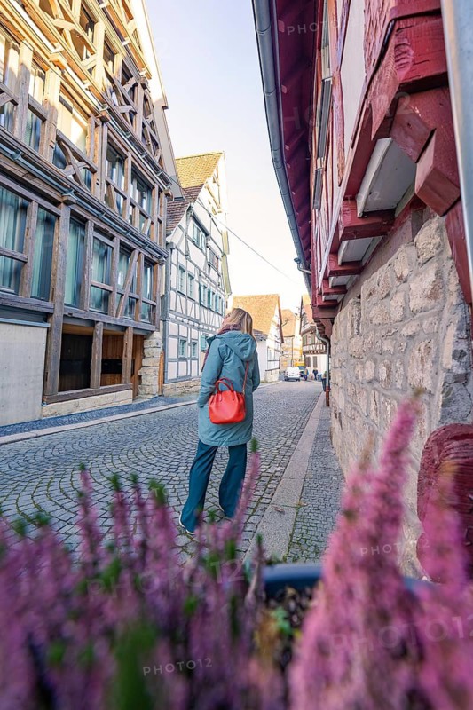 Person walks past modern and traditional half-timbered houses, mixture of old and new, Sindelfingen, Böblingen district, Germany