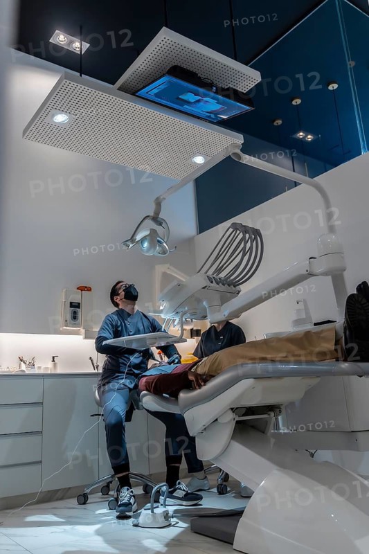 Dentist examining patient's teeth in modern dental clinic, using advanced equipment and technology for comprehensive oral care
