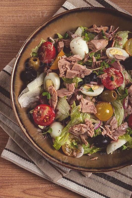 Salad with canned tuna, vegetable salad with quail eggs, lettuce, red onion, cherry tomatoes, olives, keto food, healthy food, homemade, no people