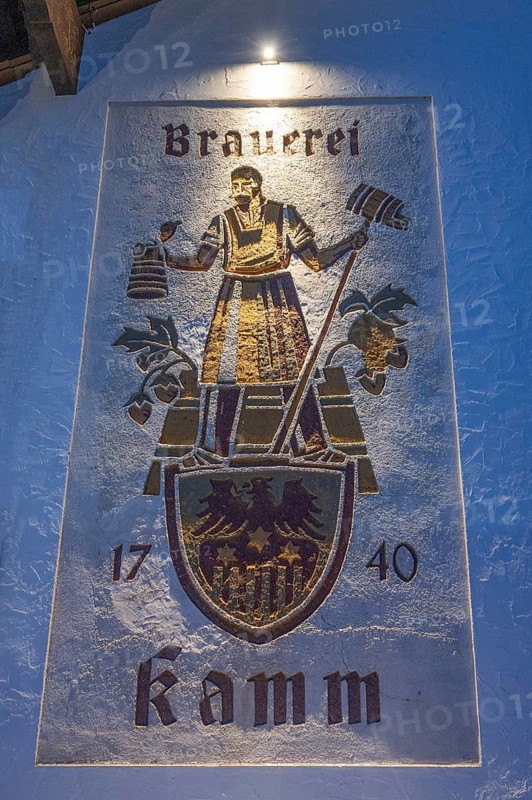 Evening lighting from the house sign of the Kammbräu inn, Zenting, Lower Bavaria, Germany