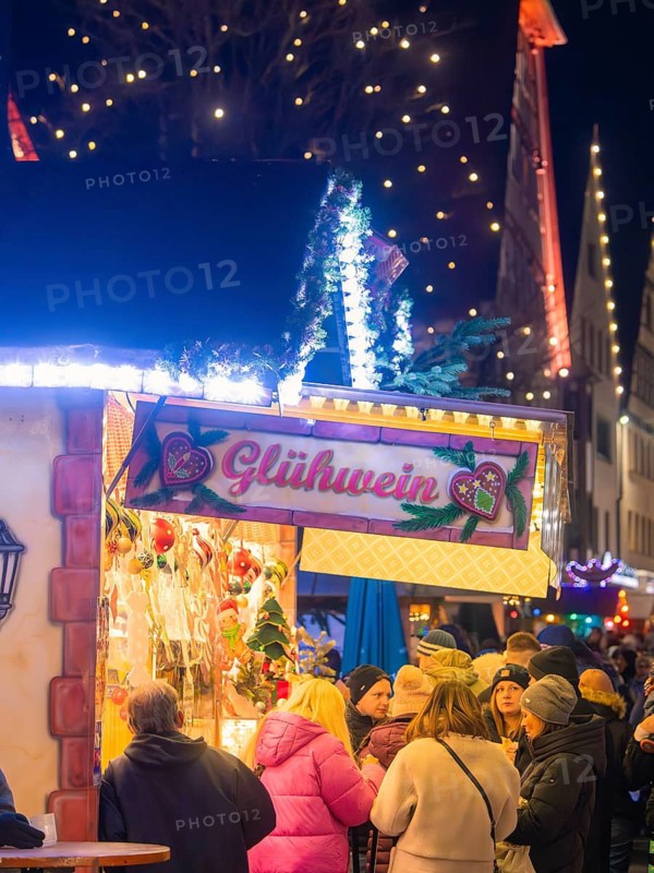 Mulled wine stand surrounded by people under festive lights, Christmas market, Nagold, Black Forest, Germany