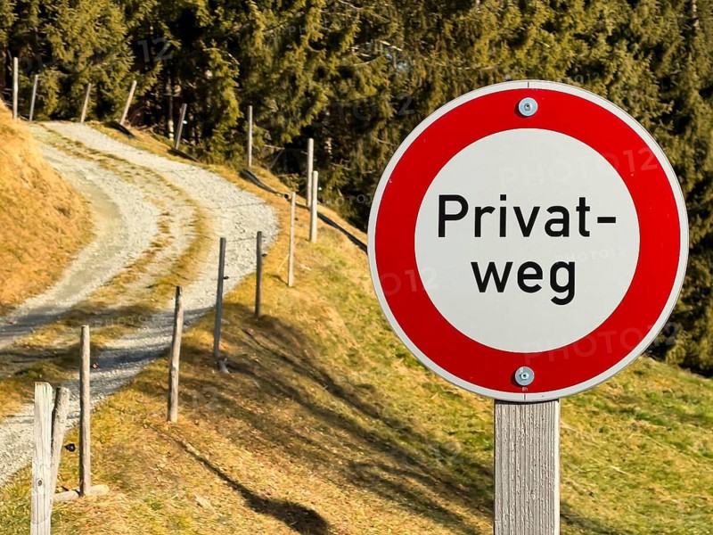 Prohibition sign, private road sign next to a dirt road in the mountains, Tyrol, Austria