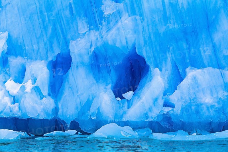 Ice wall with turquoise color and caves on a sea glacier in the Arctic, Spitsbergen, Svalbard, Norway