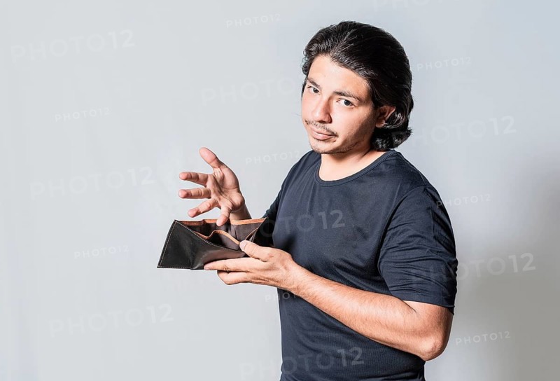 Young man with financial crisis holding wallet isolated. Sad man holding empty wallet. Unhappy man with financial crisis isolated