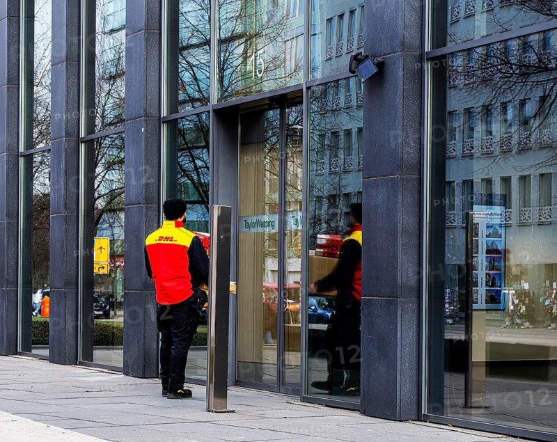 DHL parcel carrier delivering parcels, Berlin, Germany