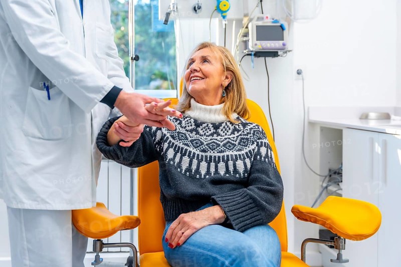 Doctor inspecting the hand of a mature woman in emergency room