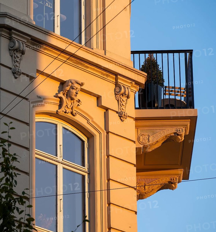 A building in warm evening light with decorative façade elements and balcony, Frederiksberg, Copenhagen, Denmark