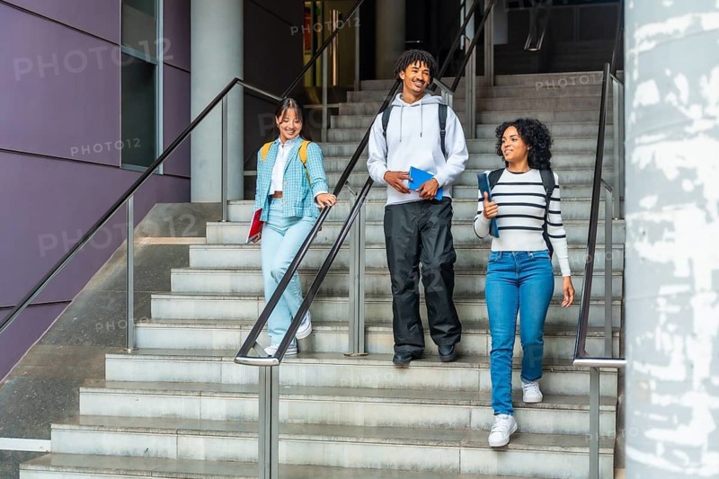 Students walking down stairs talking relaxed outside the university campus