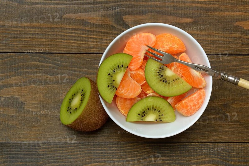 Clementine pieces and kiwi slices in peel