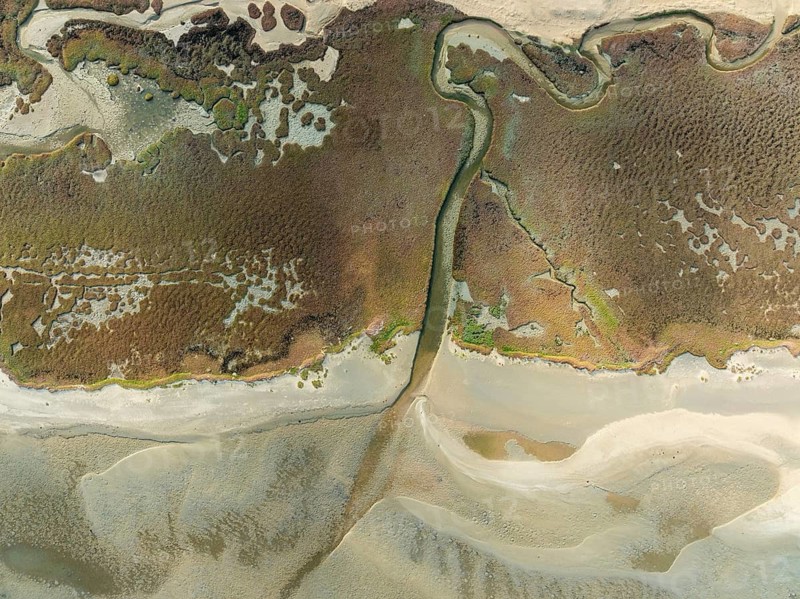 Marshes and streams at low tide in the Walvis Bay Lagoon. Aerial view. Drone shot. Namibia