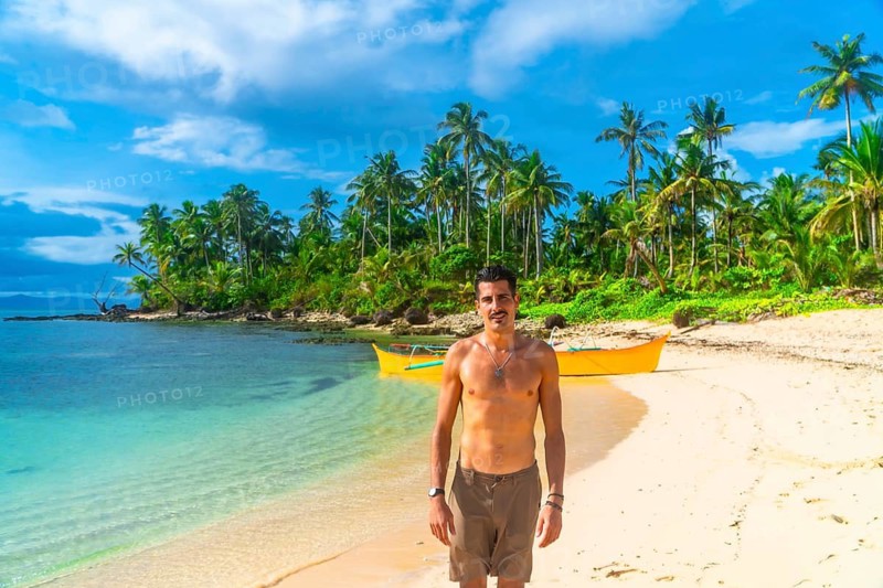 Tourist walking on guyam island beach near siargao, philippines, enjoying summer holidays in southeast asia
