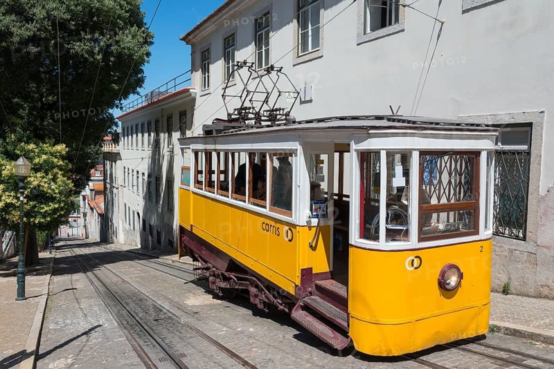 Yellow tram runs along a steep, cobbled street in front of bright buildings, funicular railway, Ascensor da Glória, Old Town, Lisbon, Lisboa, Portugal