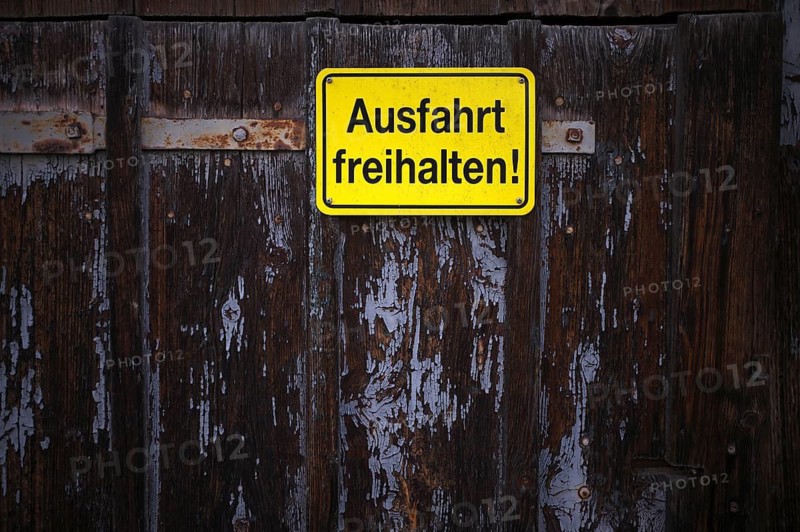 Sign AUSFAHRT FREIHALTEN, yellow, Tor tor of a wooden barn, weathered, Römerstein, Swabian Alb, Baden-Württemberg, Germany