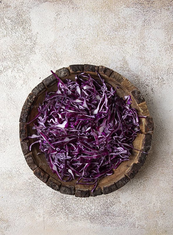 Red cabbage, sliced, in a wooden salad bowl, top view, no people