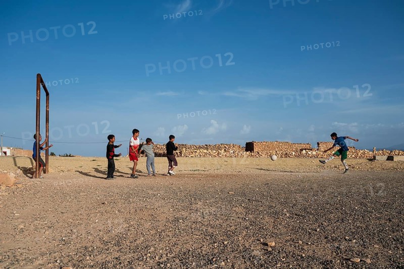 Taouloukoult, MOROCCO - OCTOBER 6, 2024: young boys spend the afternoon playing amateur football on a stone pitch