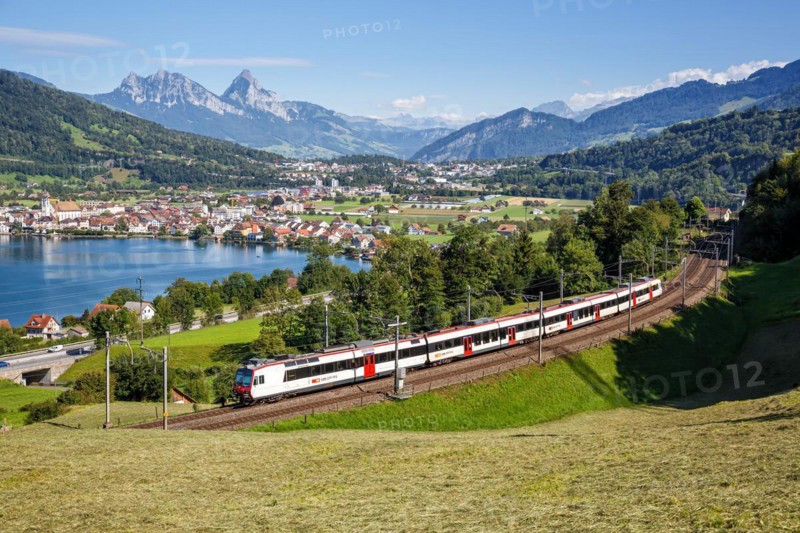 Railway passenger train of the Swiss Federal Railways SBB at the mountain Großer Mythen at Lake Zug in the Alps in Arth, Switzerland
