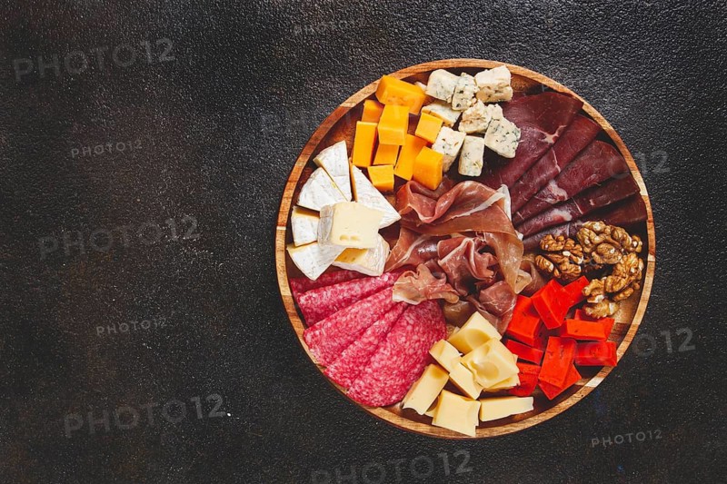 Assortment of cheese meat cuts, on a plate, top view, no people