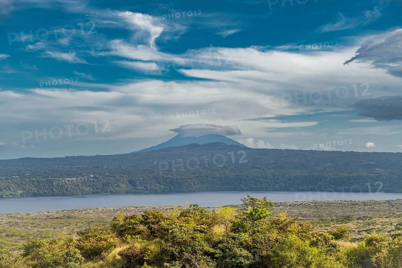 Landscape of a volcano with a blue sky surrounded by green vegetation, Nicaragua. View of a beautiful volcano on a sunny day surrounded by vegetation. Masaya