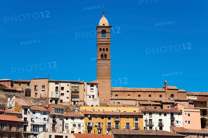 Tall stone building with a narrow tower against a clear blue sky in a historic urban area, Church, Iglesia de Santa María Magdalena, Tarazona, Zaragoza, Aragon, Spain