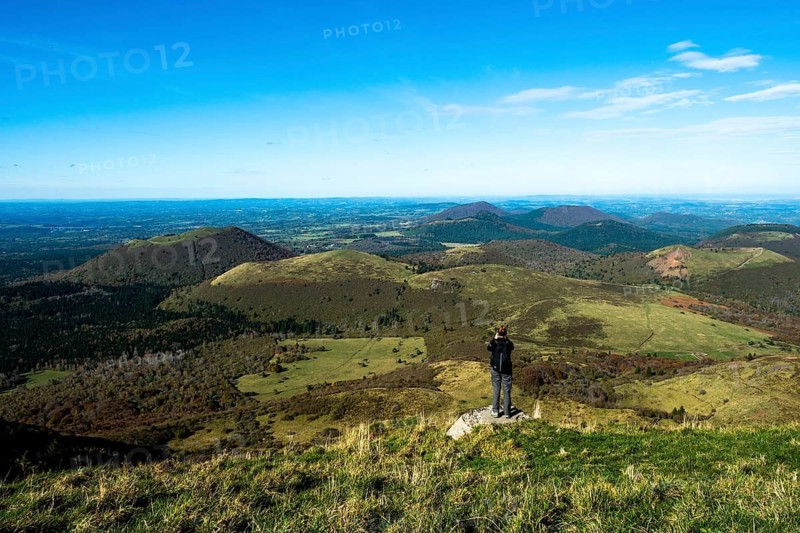 Tourist photographing in Regional natural park of Auvergne Volcanoes, Unesco World heritage, Puy de Dome department, Auvergne-Rhone-Alpes, France