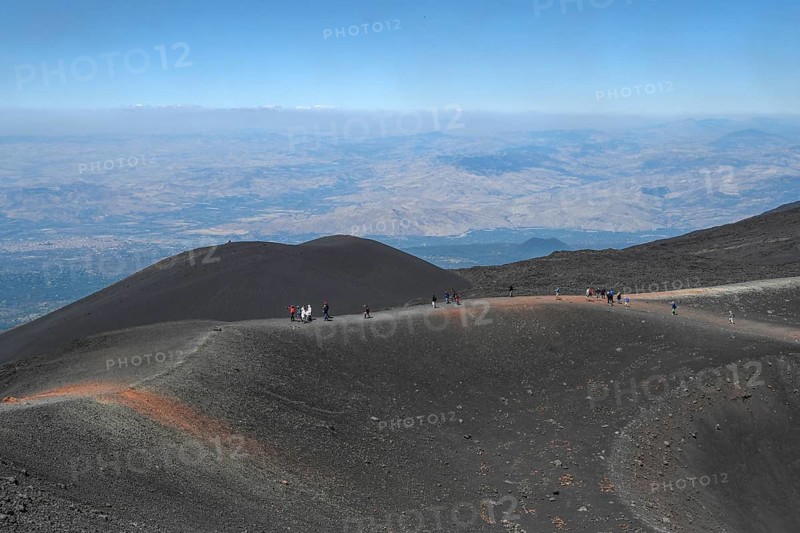 Hikers in the crater landscape of the volcano Etna, summit region, province of Catania, Sicily, Italy
