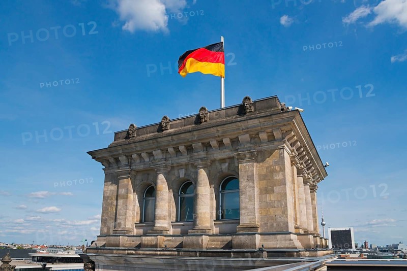 German Reichstag building with waving flag in front of blue sky, Reichstag building, German Bundestag, Berlin, Germany