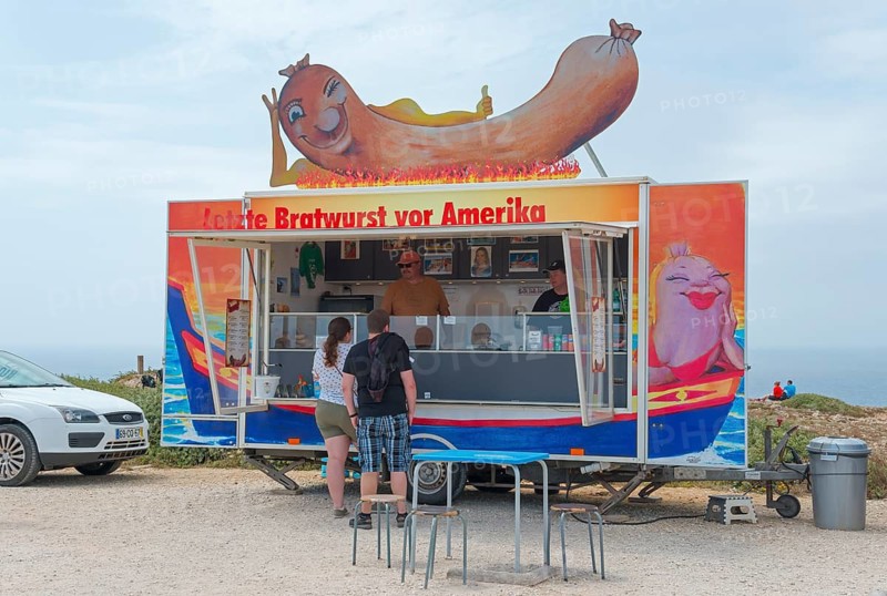 Humorous food truck selling sausages on the beach, Last sausage in front of America, Cabo de São Vicente, westernmost point of Europe, Algarve, Portugal
