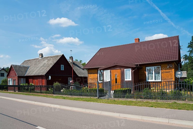 Two traditional wooden houses along a quiet village street under a blue sky, Rudawka, Plaska, Plaska, Powiat Augustowski, Podlaskie, Podlaskie, Poland
