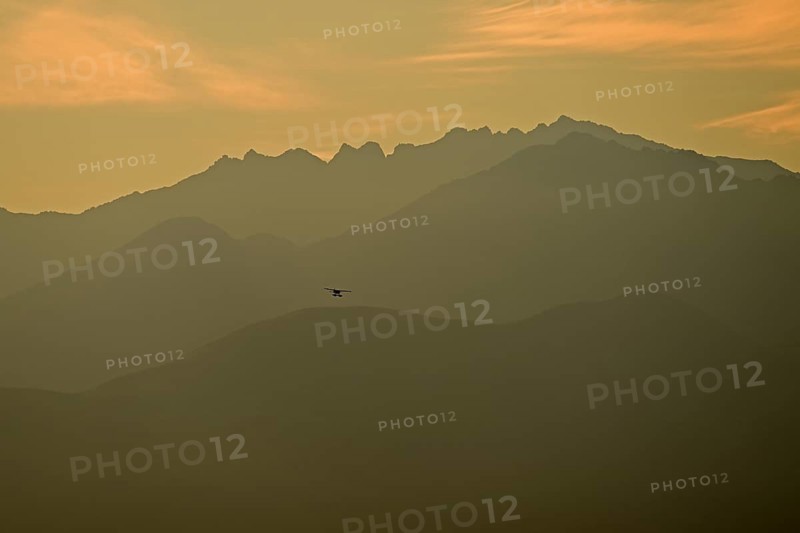 A bush plane landing against the backdrop of the Chugach Mountains, Anchorage, Alaska