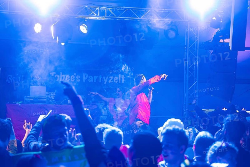 Schlager king Tobee performs in blue light in front of a rousing audience in a party tent, carnival, Schlagerkuchen Donzdorf, Göppingen district, Germany