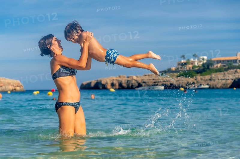 Mother and son playing and having fun together in the sea during summer holidays in cala domingos, mallorca, spain