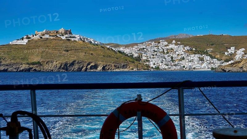 View from a ferry to a white village on a hill island under a clear sky, Chora, Astypalea, Dodecanese, Greek Islands, Greece