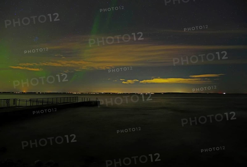 Dark night sky with northern lights and scattered clouds, sea in the foreground, beach, Tönsberg, Oslofjord, Norway